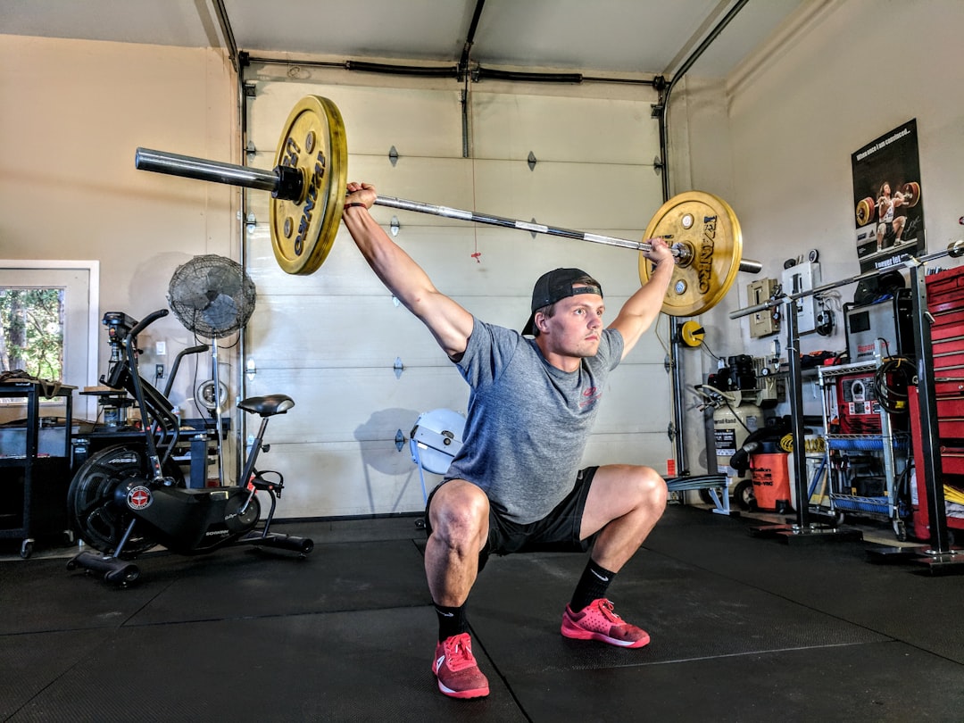 Athlete lifting a barbell during strength and conditioning training in a gym