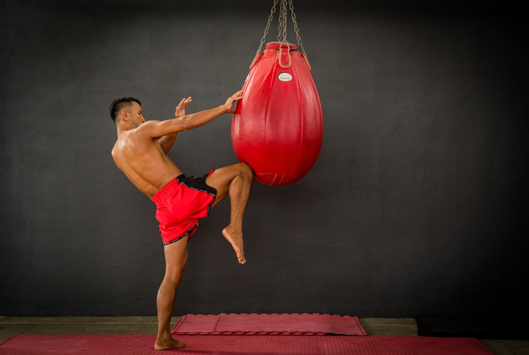 Fighter throwing a Muay Thai kick on a heavy bag during a gym training session