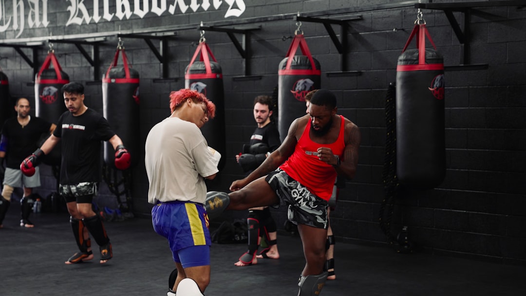 Men training kickboxing in a gym with punching bags.