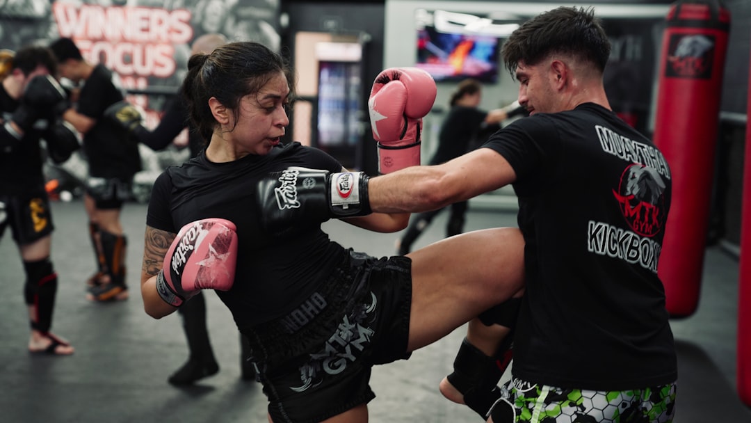 Woman kicks man during a Muay Thai training session at the gym